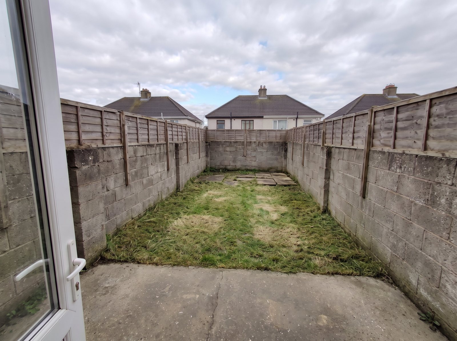 Back garden with a collapsed shed and bags, after