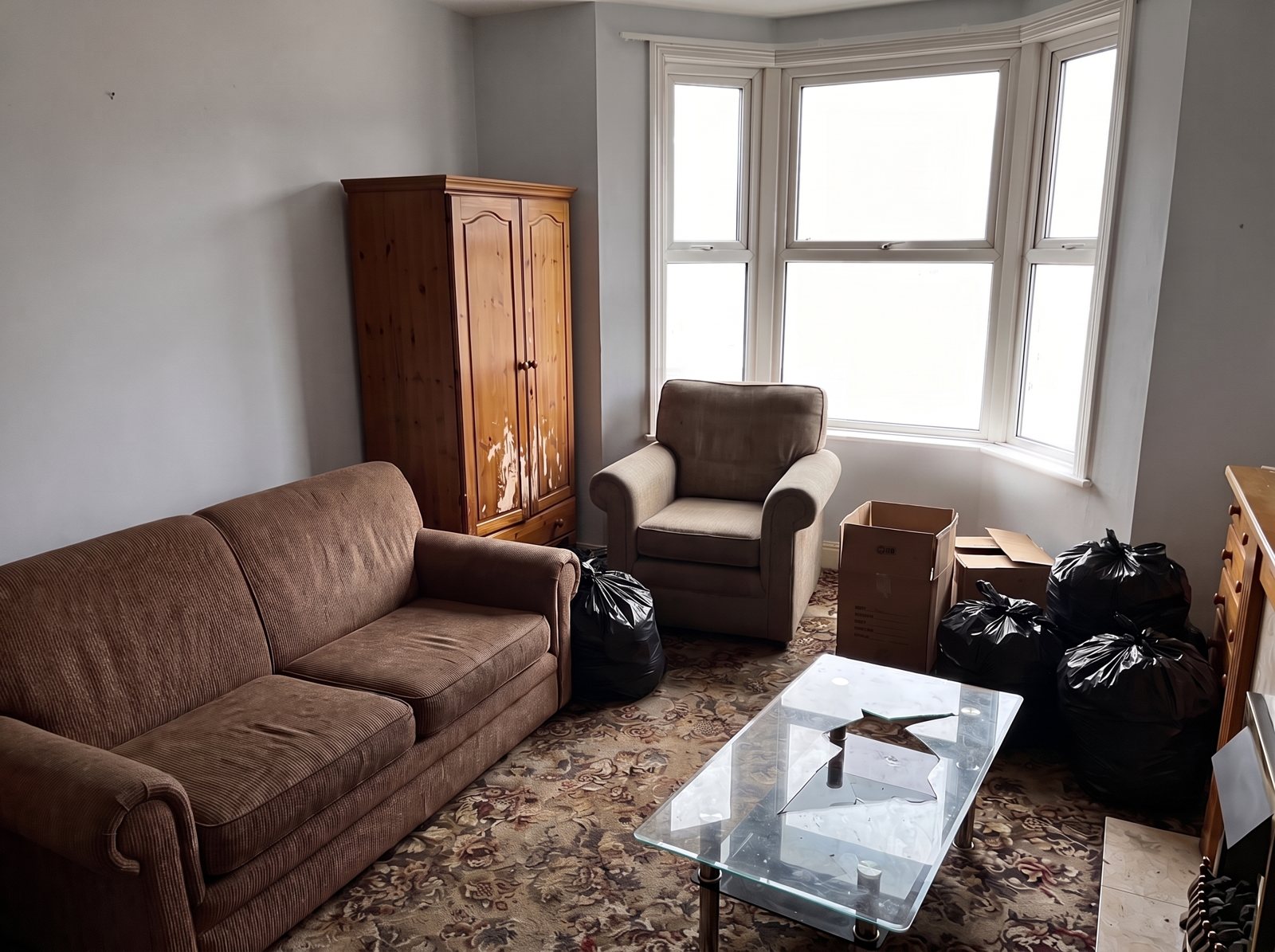Living room full of furniture and bags, before